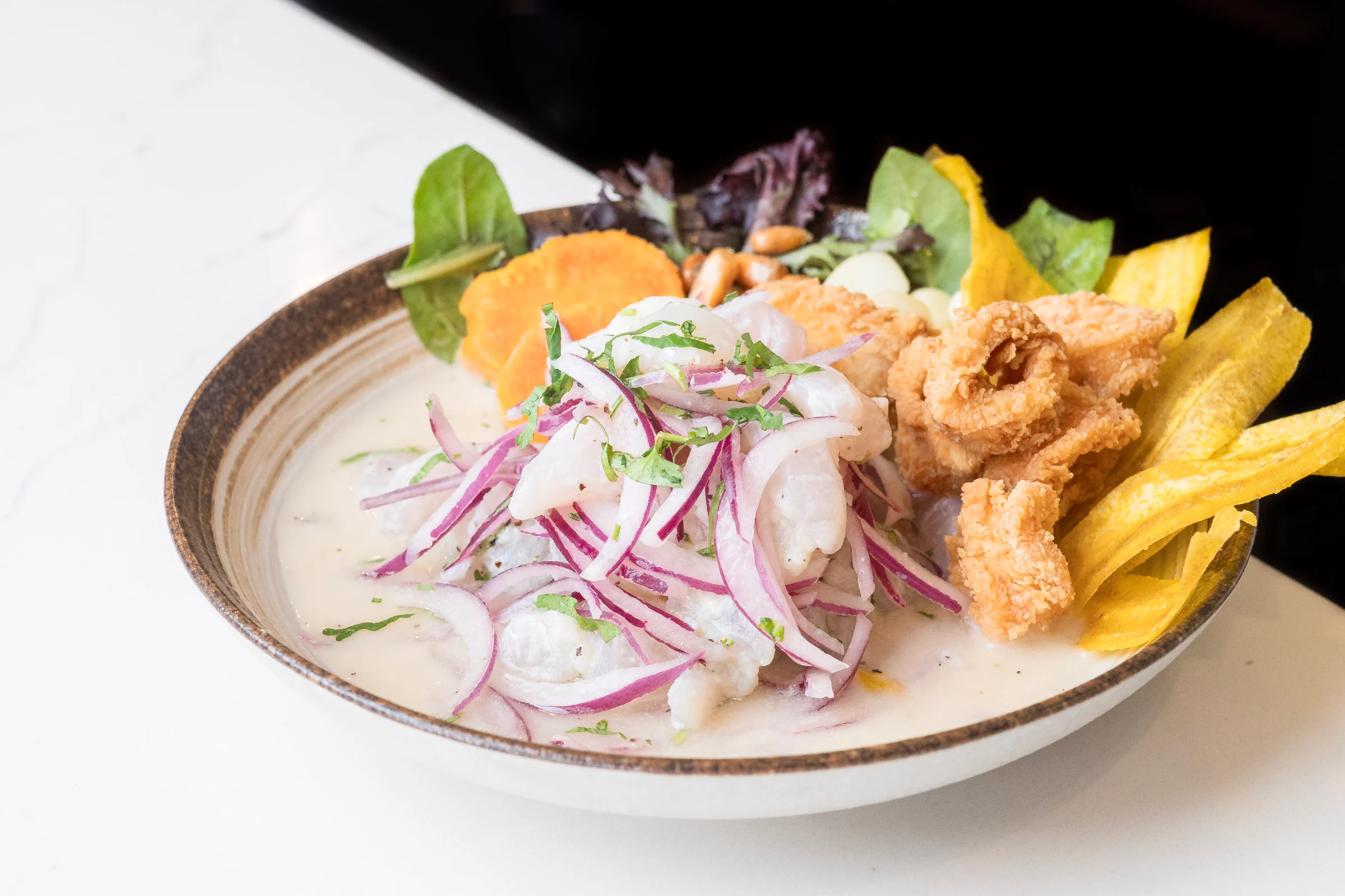 Classic ceviche with leche de tigre, red onion, sweet potato and crispy calamari at Fusionista