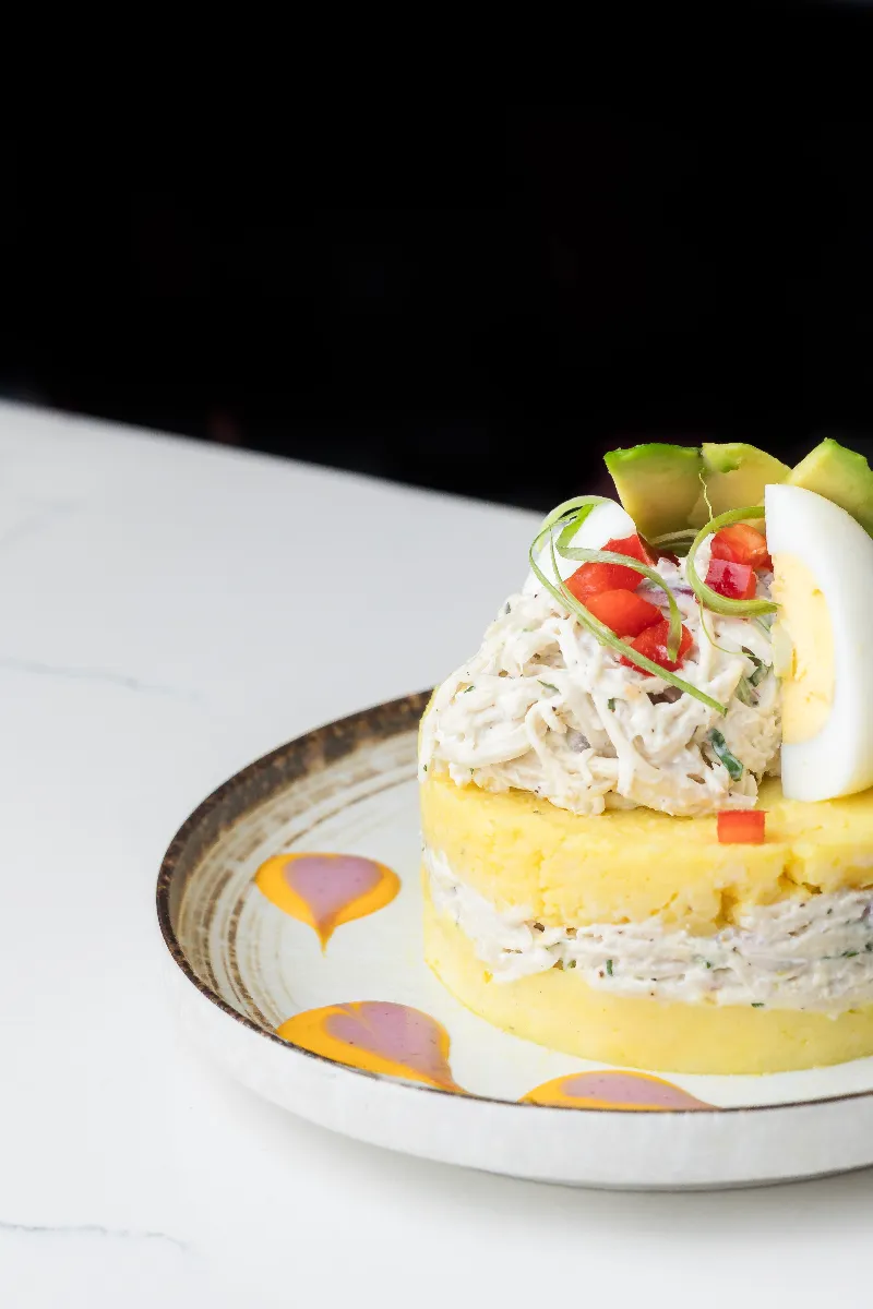 Causa de pollo — layered yellow potato with shredded chicken, avocado and boiled egg