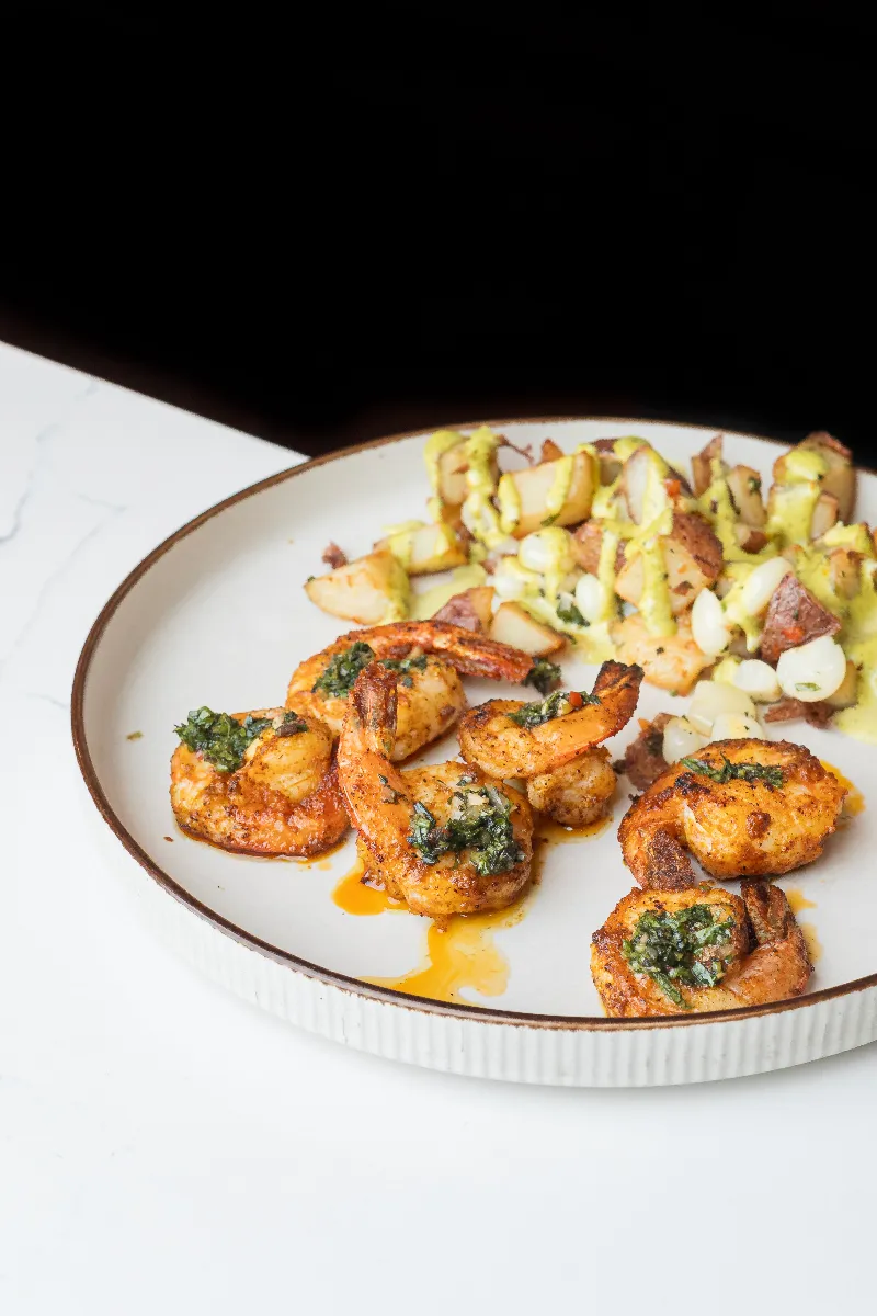 Charcoal-grilled shrimp anticucho with yellow potato and choclo