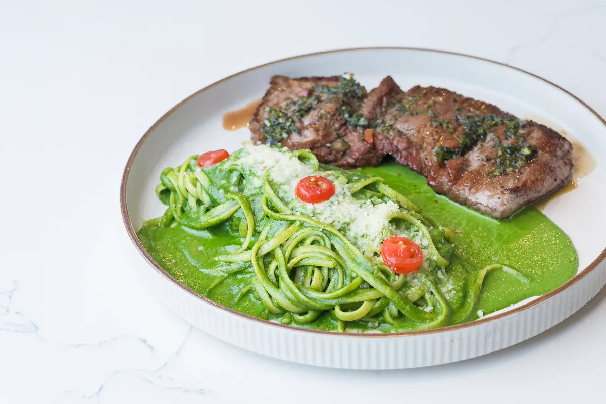 Linguine al pesto with bistec — Peruvian green pesto pasta topped with grilled steak